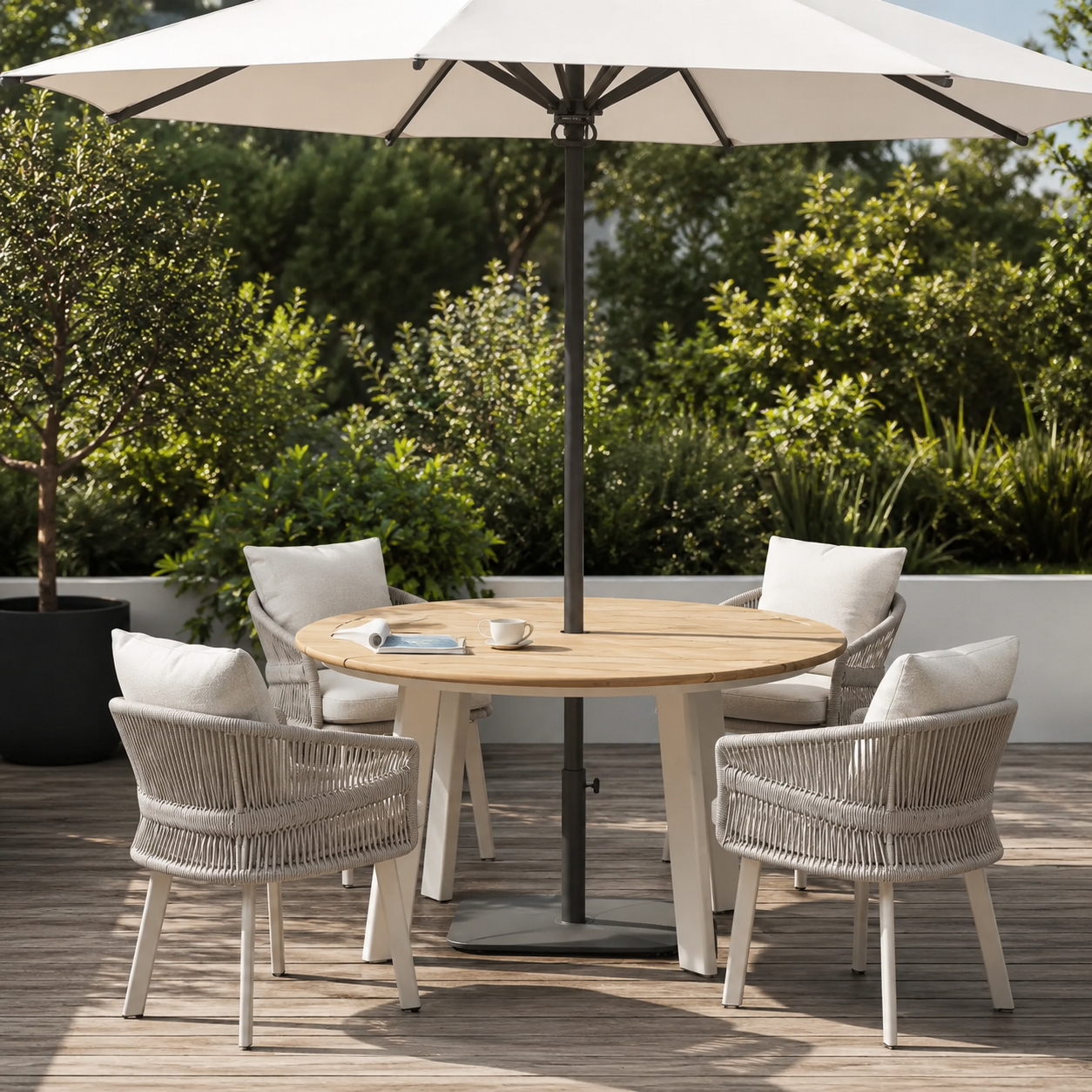 Luxury outdoor dining set with a round teak table, woven rope chairs, and a large patio umbrella on a modern terrace.